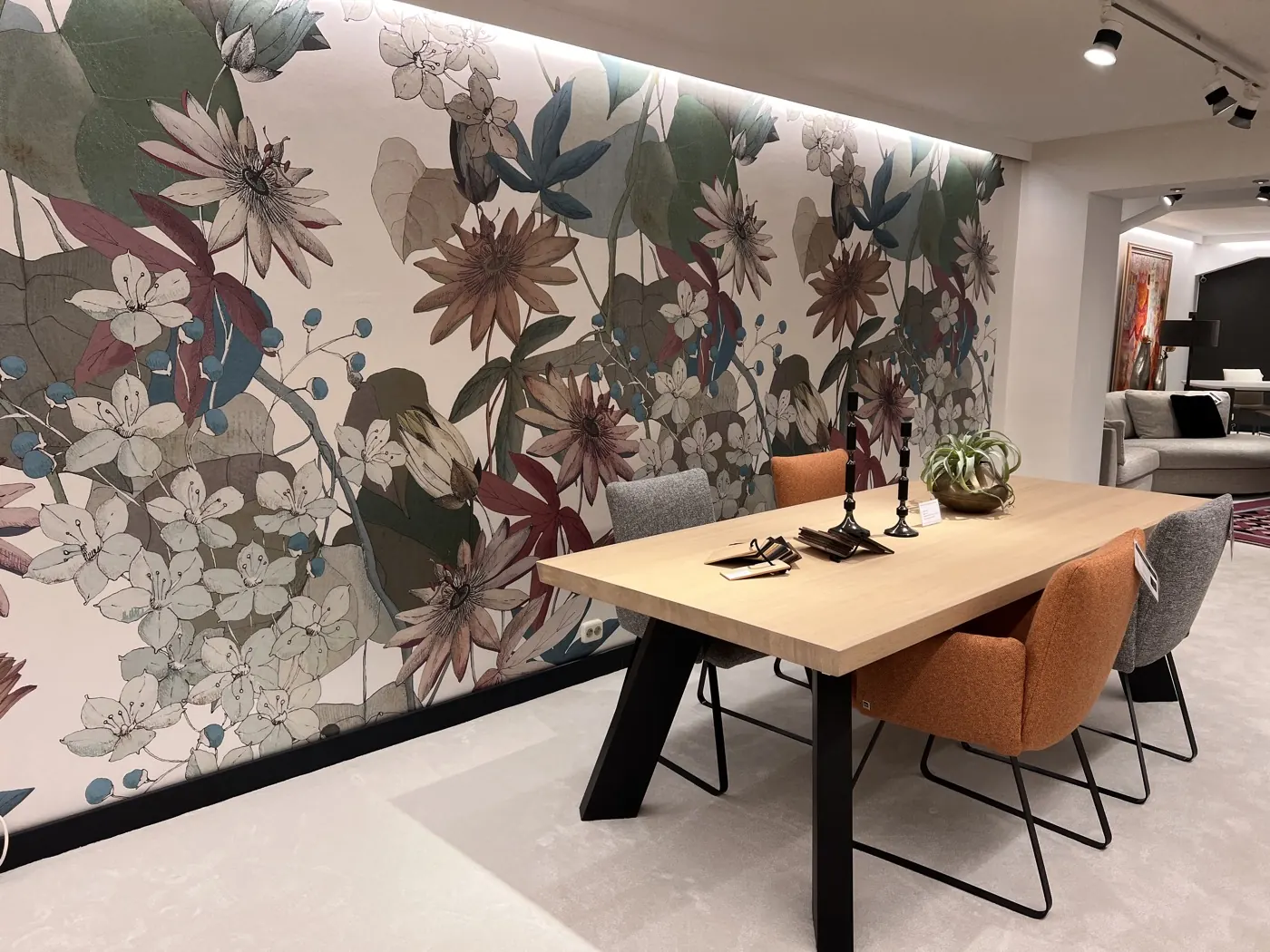 Eettafel en stoelen bij de bloemenwand in de showroom van Heida Interieurs