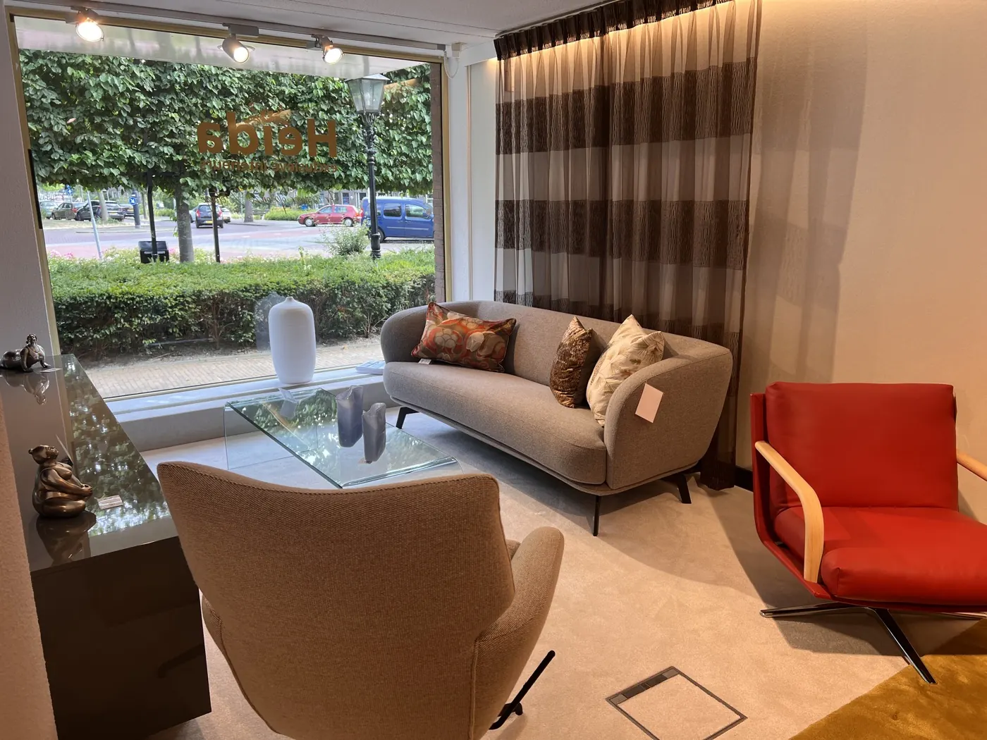 Lichte zithoek met bank en fauteuils in de showroom van Heida Interieurs in Rijswijk